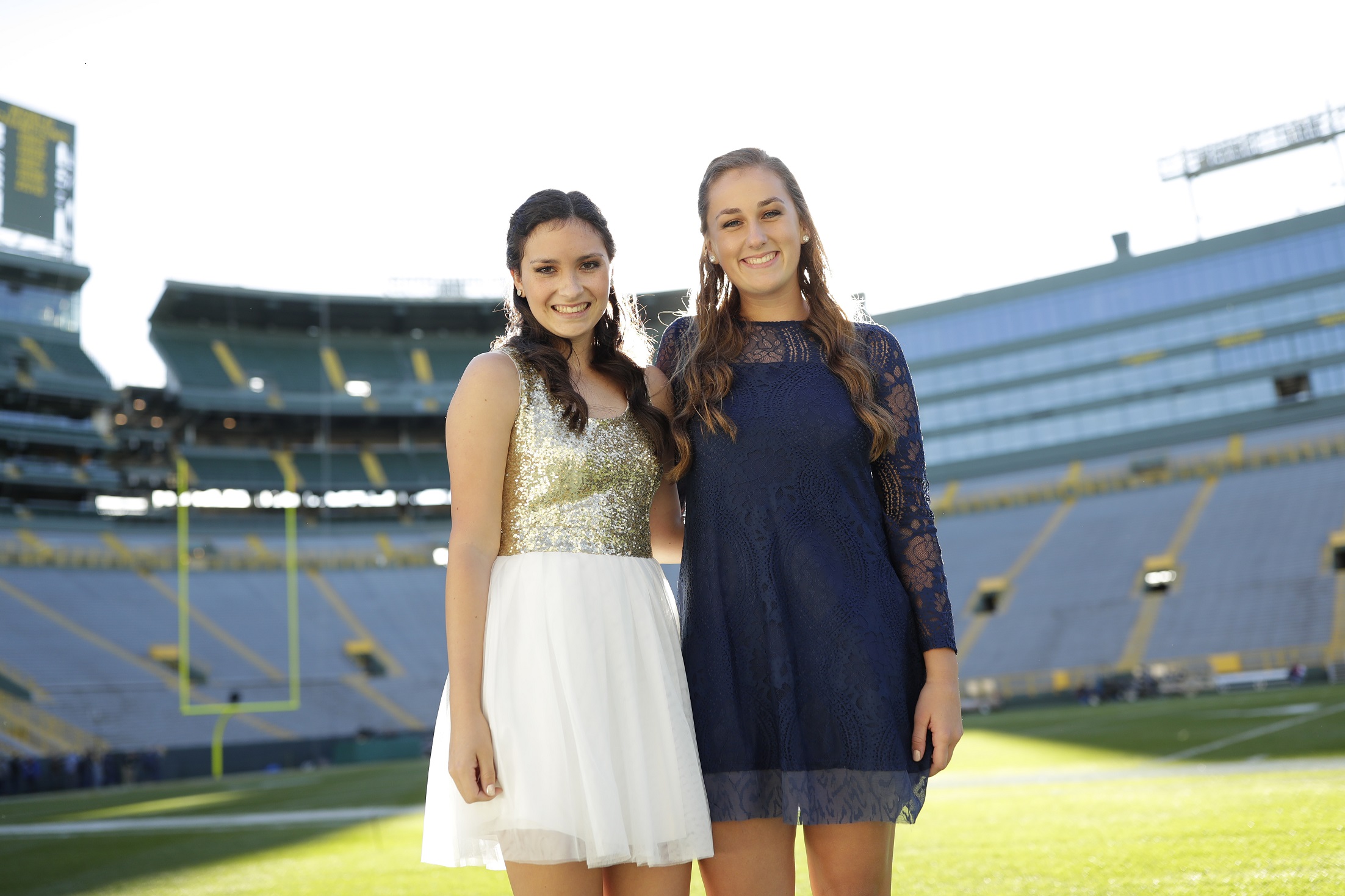 Youth standing on Lambeau Field in formal wear. 